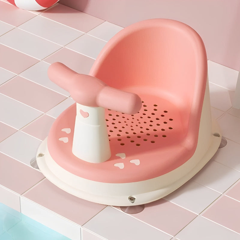 Pink and white bath seat with a child's foot inside on a tiled bathroom floor.