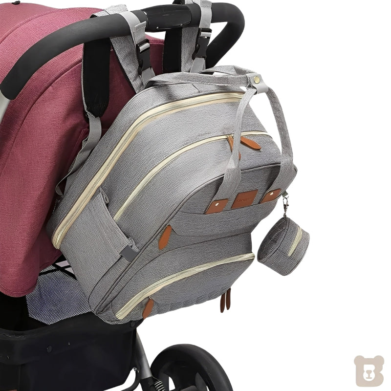 Gray backpack with brown accents attached to a stroller on a white background