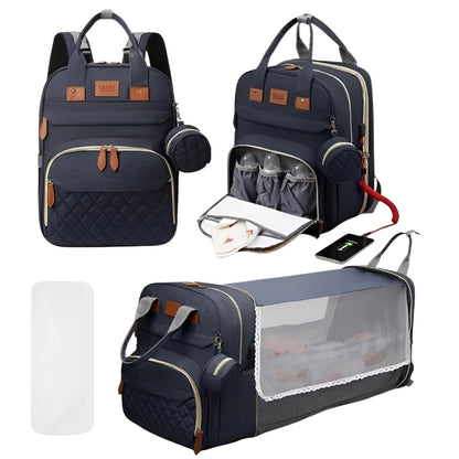 Navy blue diaper bag with multiple compartments and accessories on a white background
