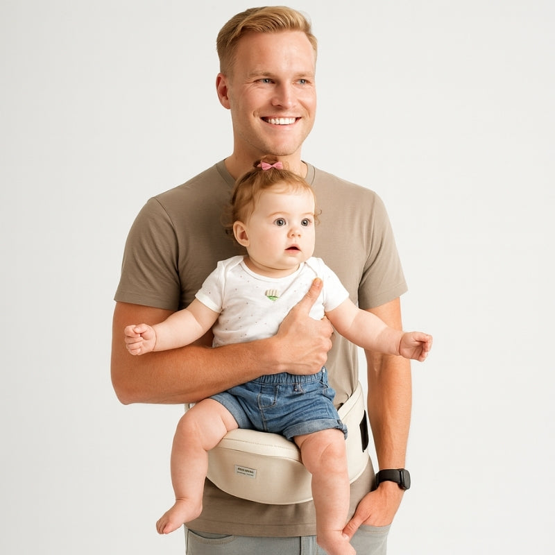 Man holding a baby in a baby carrier against a plain background