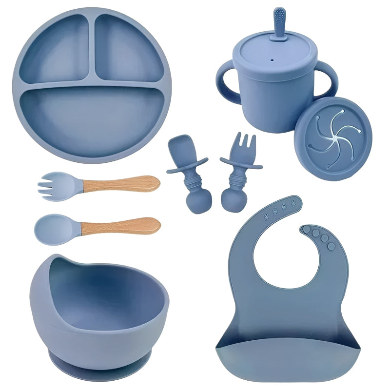 Blue silicone dining set including plate, cup, bowl, utensils, and bib on a white background