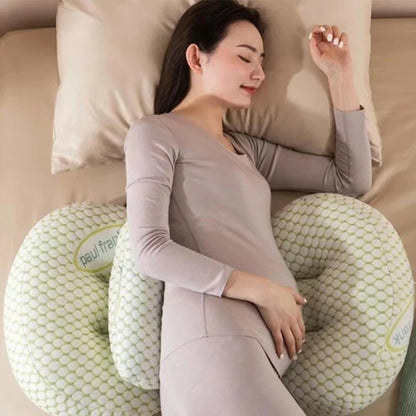 Woman lying on a U-shaped pillow with a textured surface, wearing a light gray outfit.